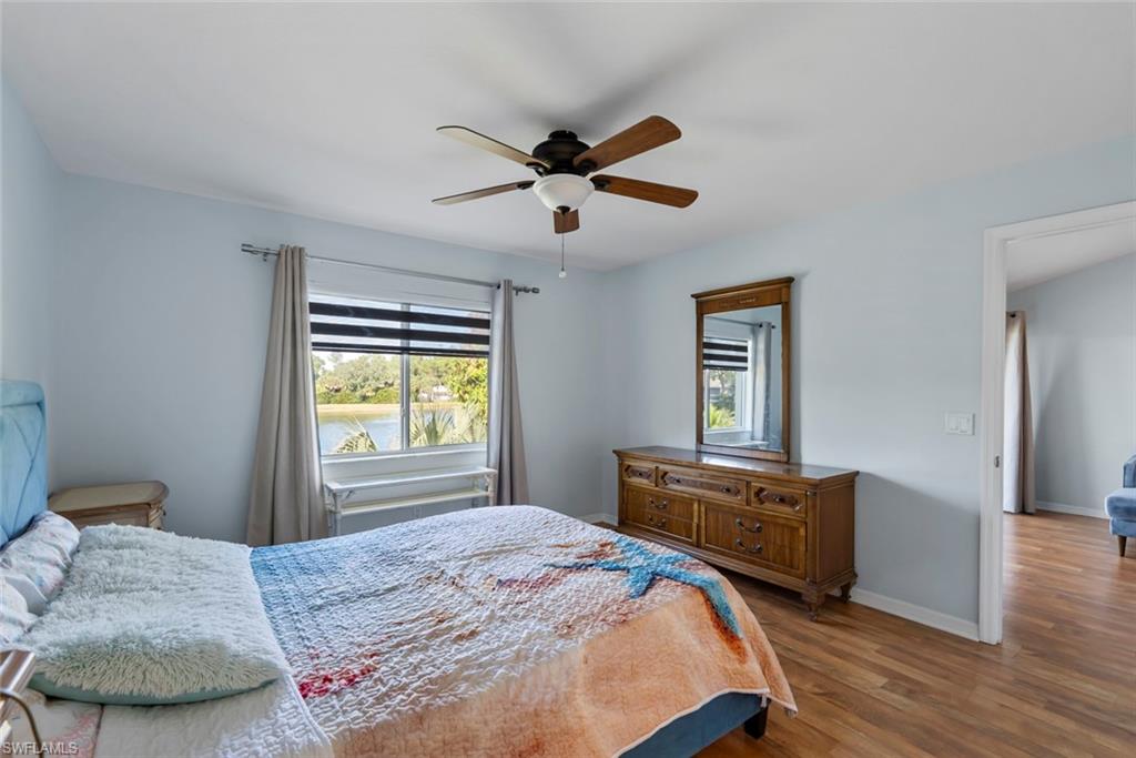 121 Gabriel Circle, Unit 1108 Naples, FL 34104 - Photo 18 of 41 a bedroom with a bed and wooden floor
