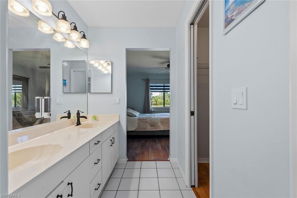 121 Gabriel Circle, Unit 1108 Naples, FL 34104 - Photo 21 of 41 a en suite bathroom with a sink a mirror and a shower