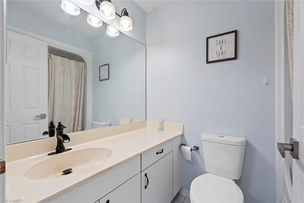 121 Gabriel Circle, Unit 1108 Naples, FL 34104 - Photo 25 of 41 a bathroom with a toilet sink and mirror