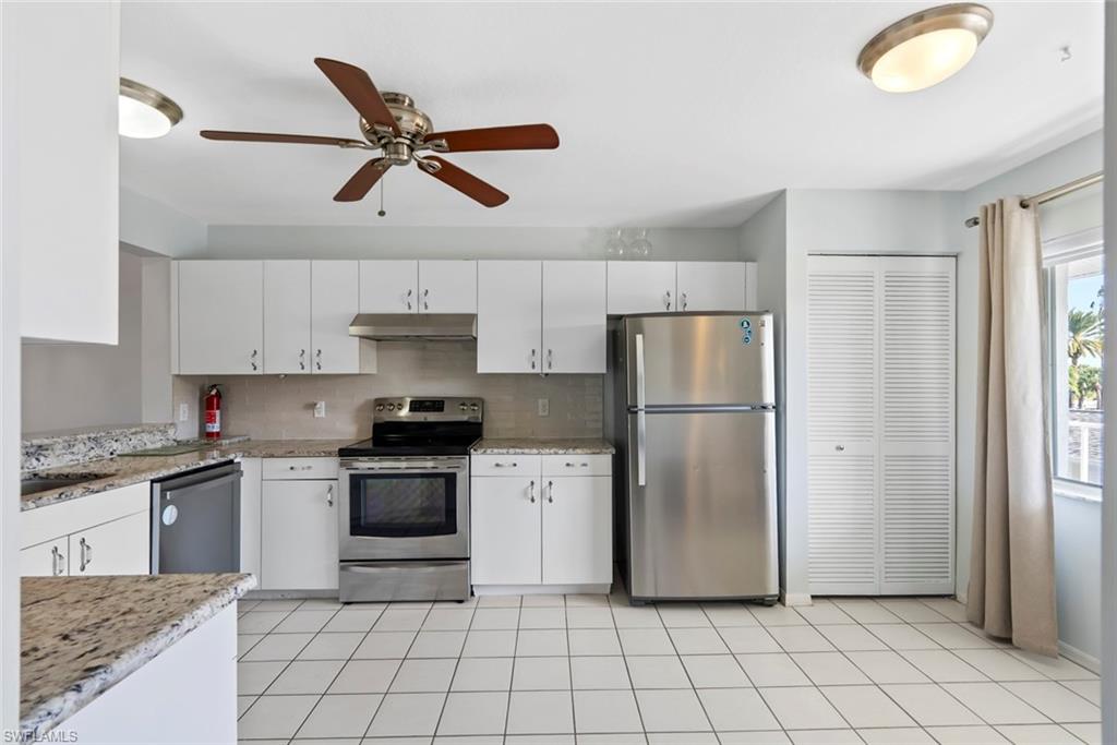 121 Gabriel Circle, Unit 1108 Naples, FL 34104 - Photo 4 of 41 a kitchen with stainless steel appliances granite countertop a stove a refrigerator and a sink