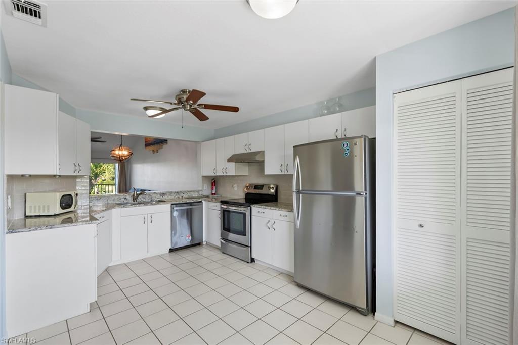 121 Gabriel Circle, Unit 1108 Naples, FL 34104 - Photo 5 of 41 a kitchen with stainless steel appliances granite countertop a refrigerator sink and stove