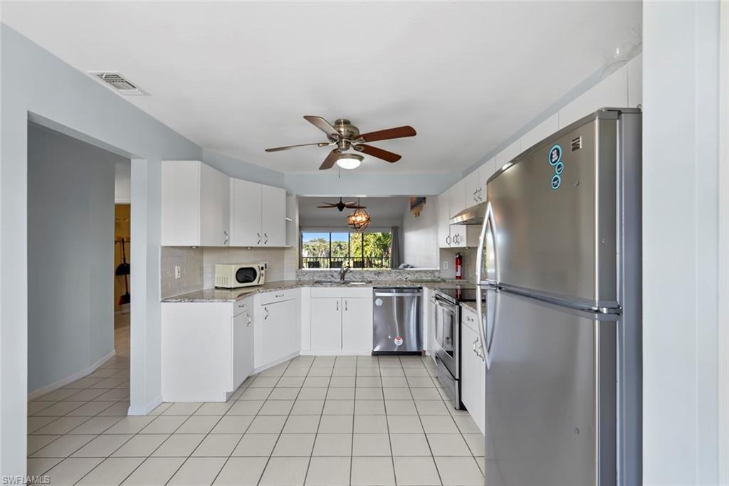 121 Gabriel Circle, Unit 1108 Naples, FL 34104 - Photo 7 of 41 a kitchen with white cabinets and white appliances