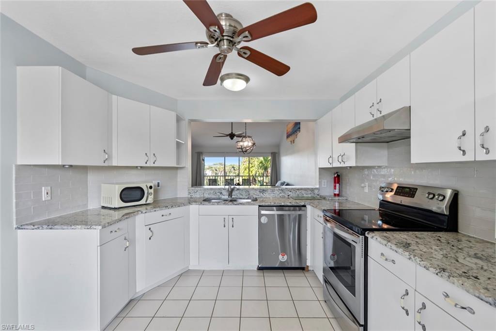 121 Gabriel Circle, Unit 1108 Naples, FL 34104 - Photo 8 of 41 a kitchen with a stove sink and cabinets