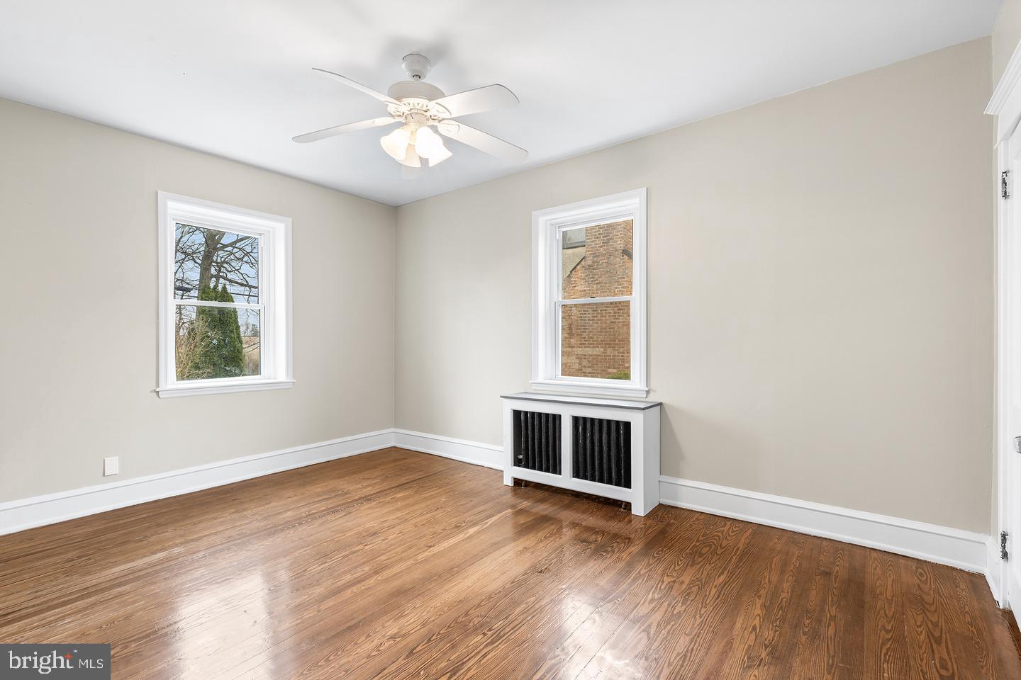 103 Llandaff Road Havertown, PA 19083 - Photo 12 of 36 an empty room with wooden floor chandelier fan and windows