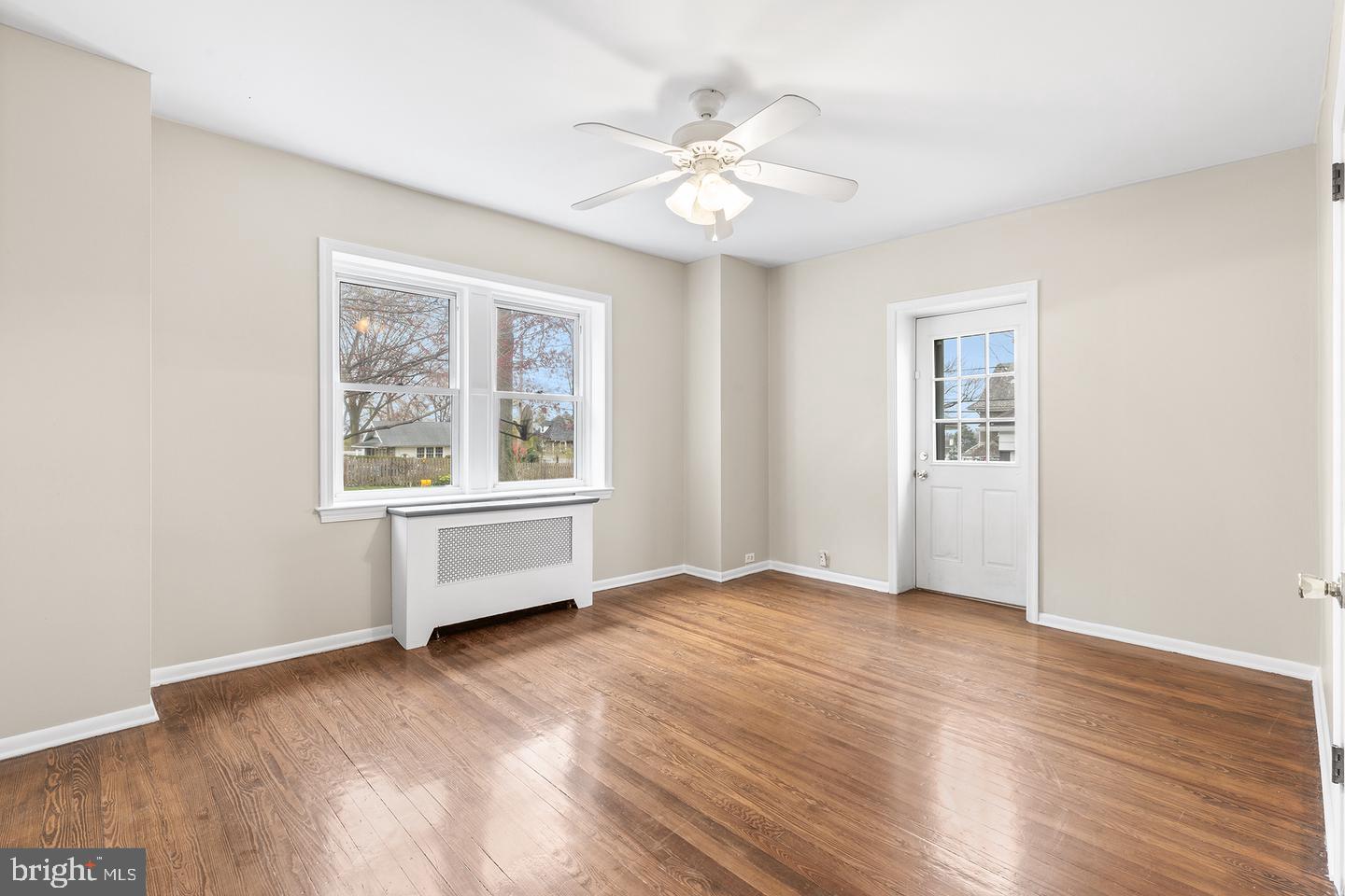 103 Llandaff Road Havertown, PA 19083 - Photo 14 of 36 an empty room with wooden floor chandelier fan and windows