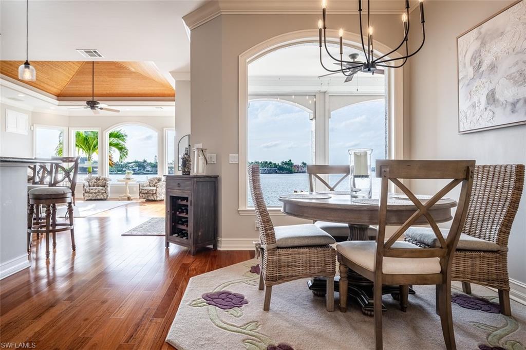 1942 Kingfish Road Naples, FL 34102 - Photo 18 of 43 a view of a dining room with furniture a chandelier and wooden floor