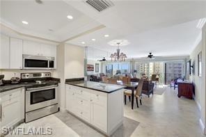 1 Bluebill Avenue, Unit 707 Naples, FL 34108 - Photo 11 of 16 Kitchen featuring a chandelier, appliances with stainless steel finishes, kitchen peninsula, and white cabinetry