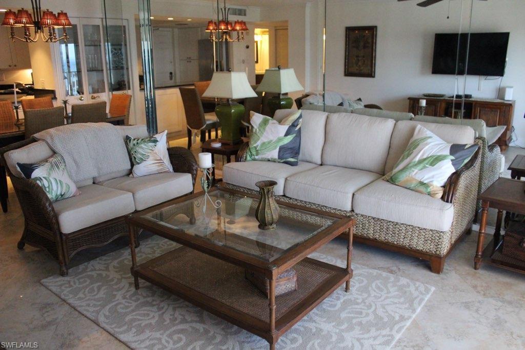 1 Bluebill Avenue, Unit 707 Naples, FL 34108 - Photo 15 of 16 Living room featuring a notable chandelier