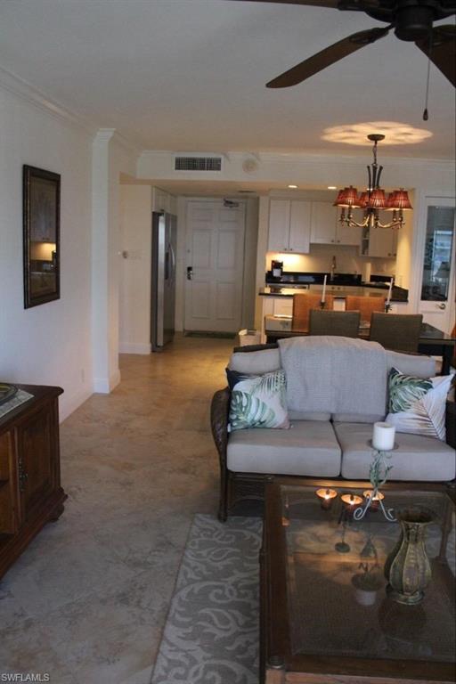 1 Bluebill Avenue, Unit 707 Naples, FL 34108 - Photo 16 of 16 Living room featuring crown molding and ceiling fan with notable chandelier
