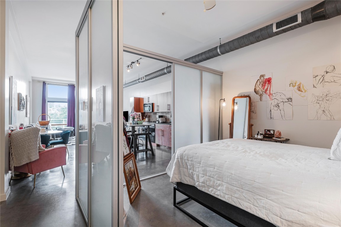 2124 East 6th Street, Unit 305 Austin, TX 78702 - Photo 22 of 35 a bedroom with a bed with wooden floor