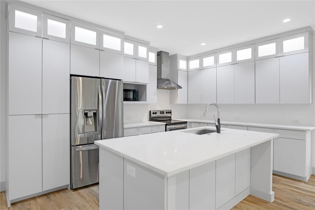 2606 Fordham Road Dallas, TX 75216 - Photo 10 of 19 Modern kitchen featuring light wood-finish flooring and extensive white cabinetry