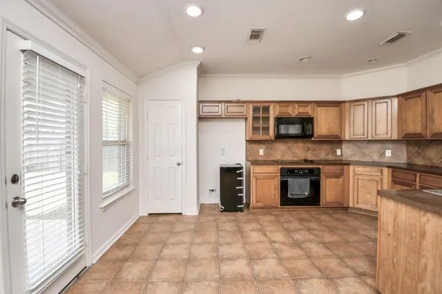 a large kitchen with granite countertop a sink and cabinets