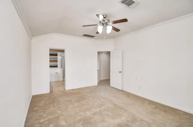 an empty room with closet and a chandelier fan
