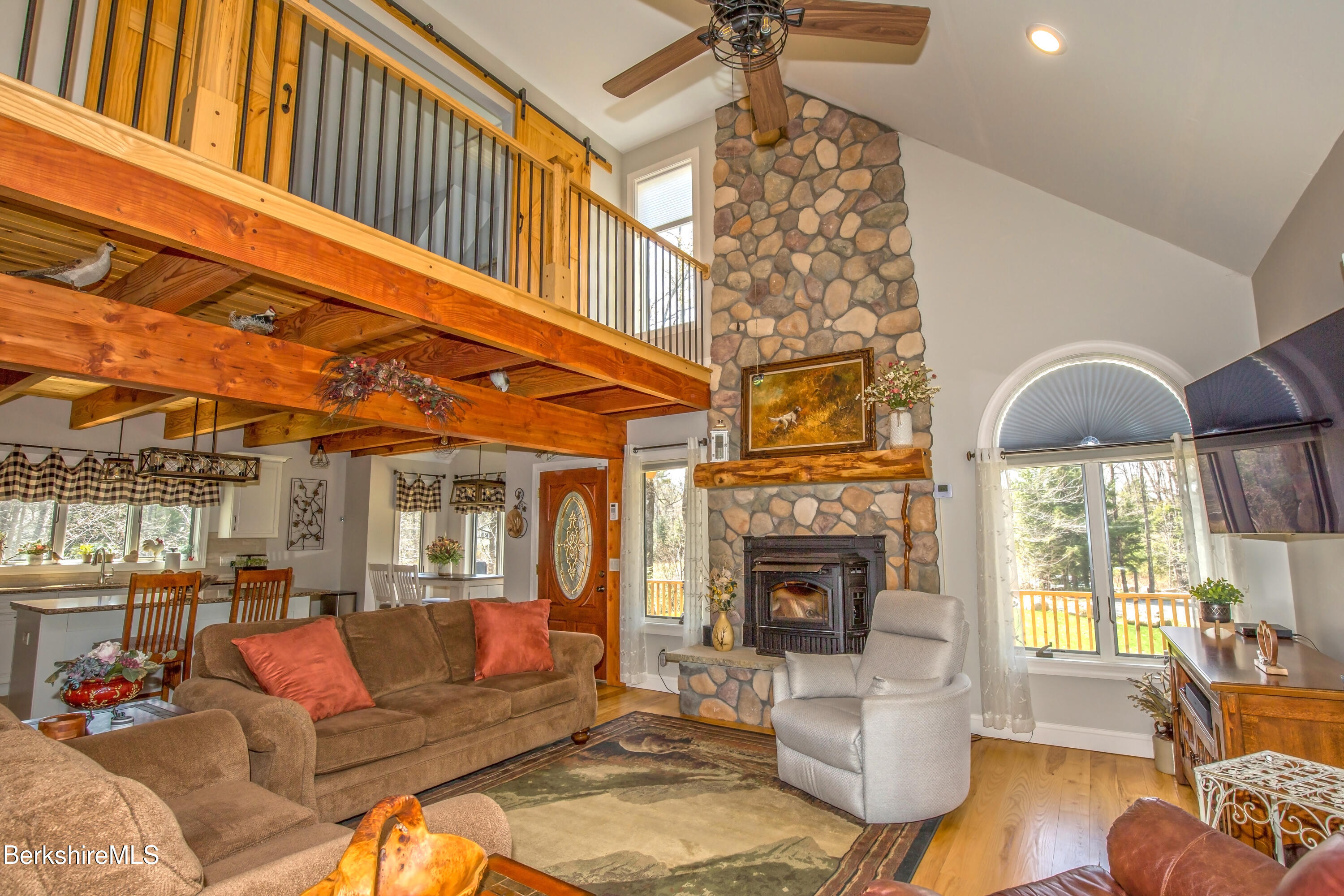 24 Evergreen Drive Otis, MA 01253 - Photo 21 of 41 a living room with furniture a fireplace and a chandelier