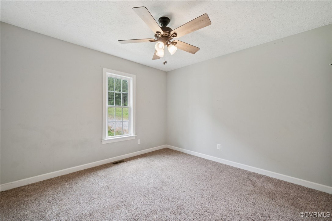 241 Deep Landing Road Tappahannock, VA 22560 - Photo 20 of 33 Carpeted spare room with baseboards, a ceiling fan