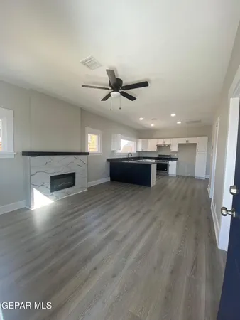a view of empty room with wooden floor and a ceiling fan