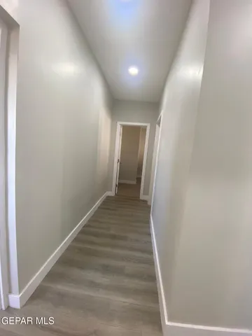 a view of a hallway with wooden floor