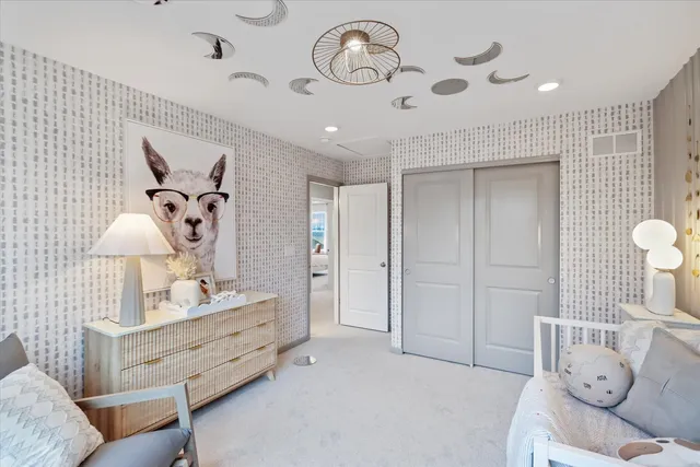 a spacious bedroom with a bed and a lamp