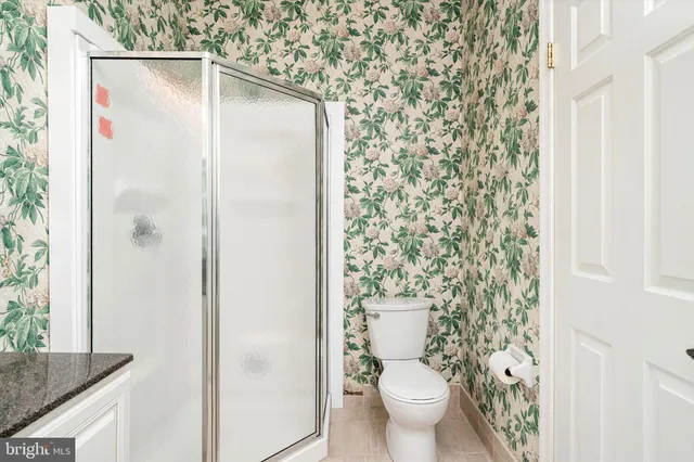 a view of an empty room with a window and a kitchen
