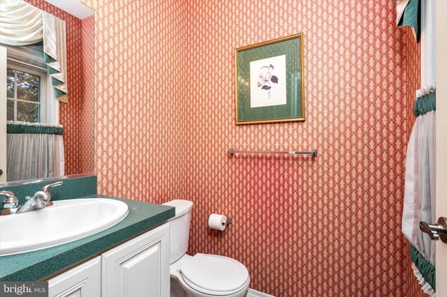 a bathroom with a granite countertop toilet sink and mirror