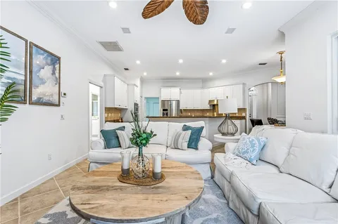 a living room with stainless steel appliances couches a dining table and kitchen view