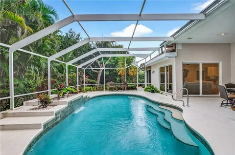 a view of a swimming pool with a patio and a yard