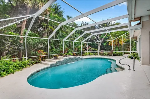 a view of a swimming pool with outdoor seating and plants