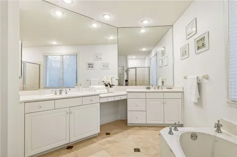 a bathroom with a sink double vanity mirror and bathtub