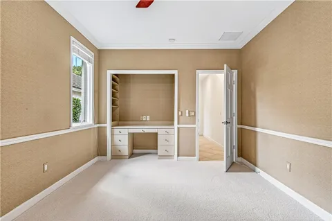 a view of an empty room with window and cabinet