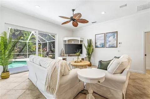a living room with furniture a flat screen tv and a large window