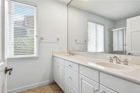 a bathroom with a double vanity sink and a window