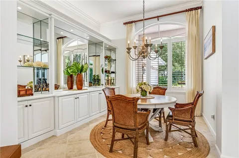a dining room with furniture a chandelier and wooden floor
