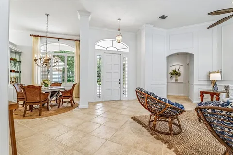a dining room with furniture a chandelier and wooden floor