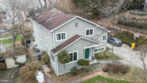 a view of a yard in front of a house with plants and large tree