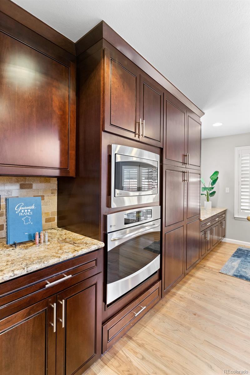 6681 Secrest Circle Arvada, CO 80007 - Photo 19 of 50 a kitchen with granite countertop stainless steel appliances and wooden cabinets