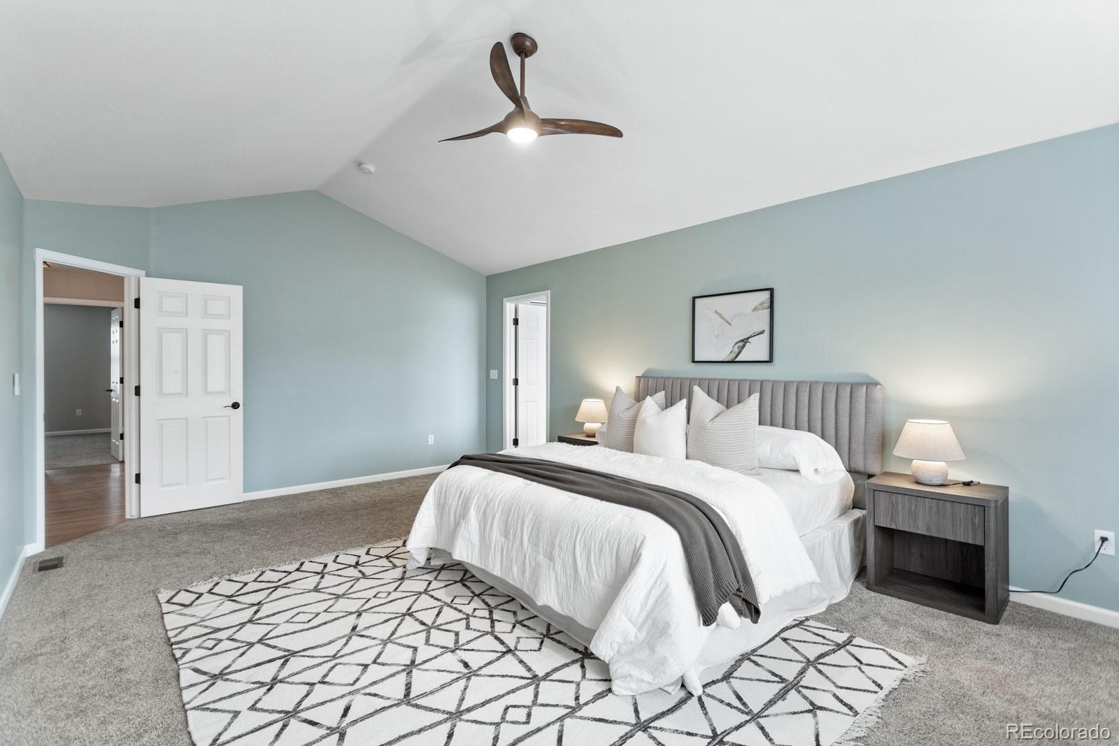 6681 Secrest Circle Arvada, CO 80007 - Photo 32 of 50 a bedroom with a large bed and a lamp