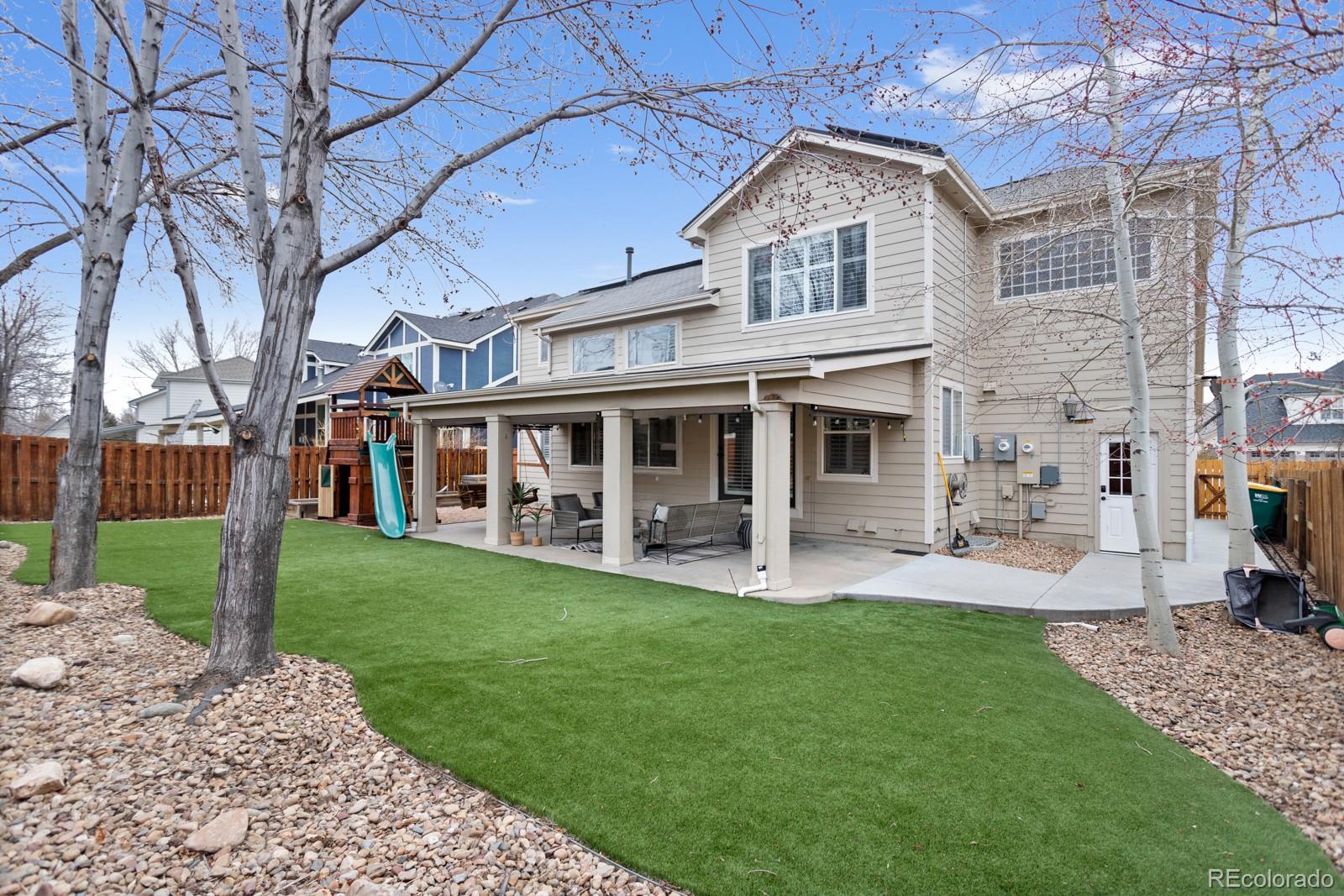 6681 Secrest Circle Arvada, CO 80007 - Photo 45 of 50 a front view of a house with a garden and porch