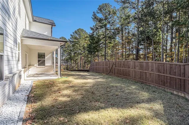 a view of a yard with wooden fence and a large tree