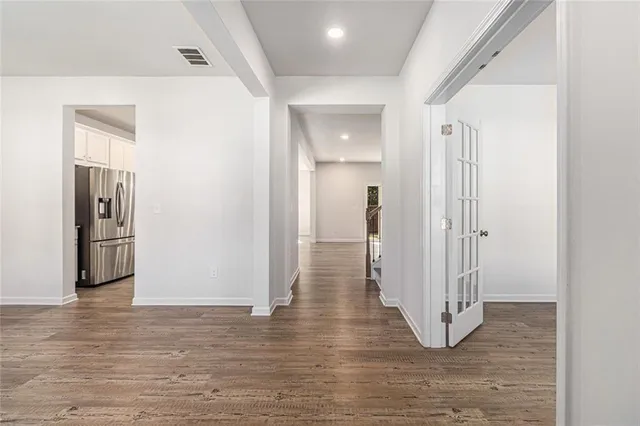 a view of a hallway with wooden floor and staircase