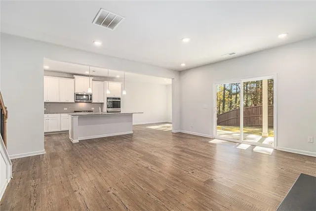 a view of a kitchen with wooden floor and a window