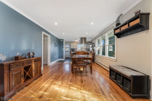 a kitchen with stainless steel appliances kitchen island granite countertop a table chairs and a refrigerator