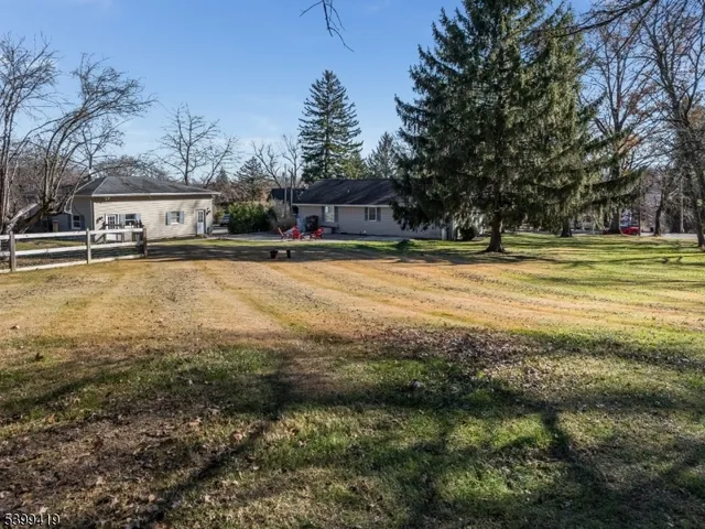 a view of a lake with a floor to ceiling window next to a yard