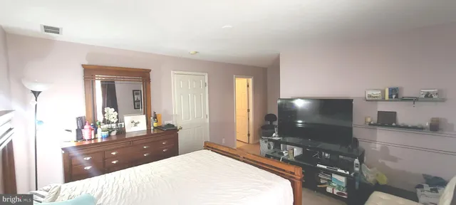 a spacious bedroom with a bed and a large window