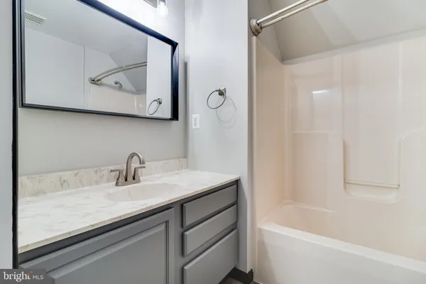 a bathroom with a granite countertop sink a toilet and bathtub