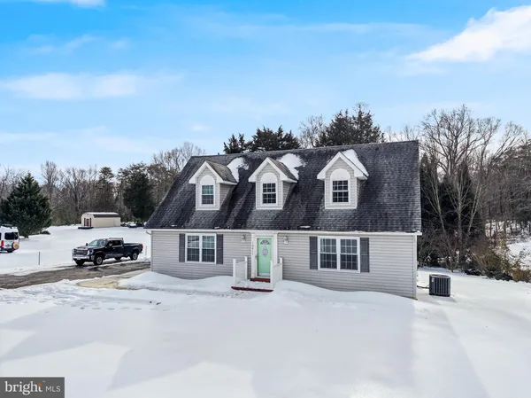 a front view of a house with a yard and parking