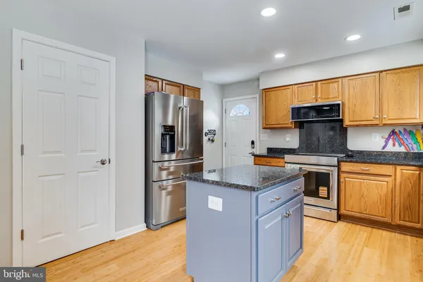 a kitchen with granite countertop stainless steel appliances and wooden cabinets