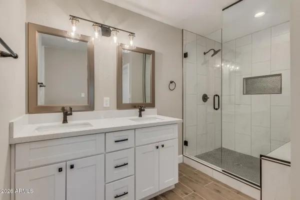 a bathroom with a double vanity sink mirror and shower