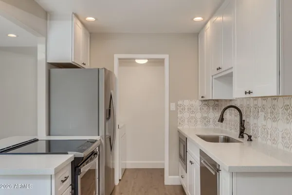a kitchen with stainless steel appliances granite countertop a sink and a refrigerator