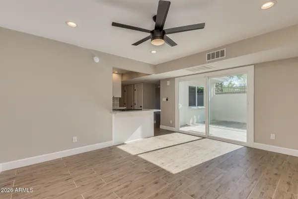 a view of a big room with wooden floor and a ceiling fan