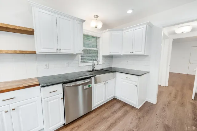 a kitchen with granite countertop white cabinets and white appliances